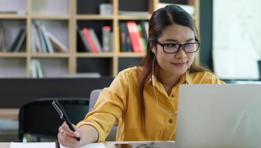 woman wearing headphones engaged in online education