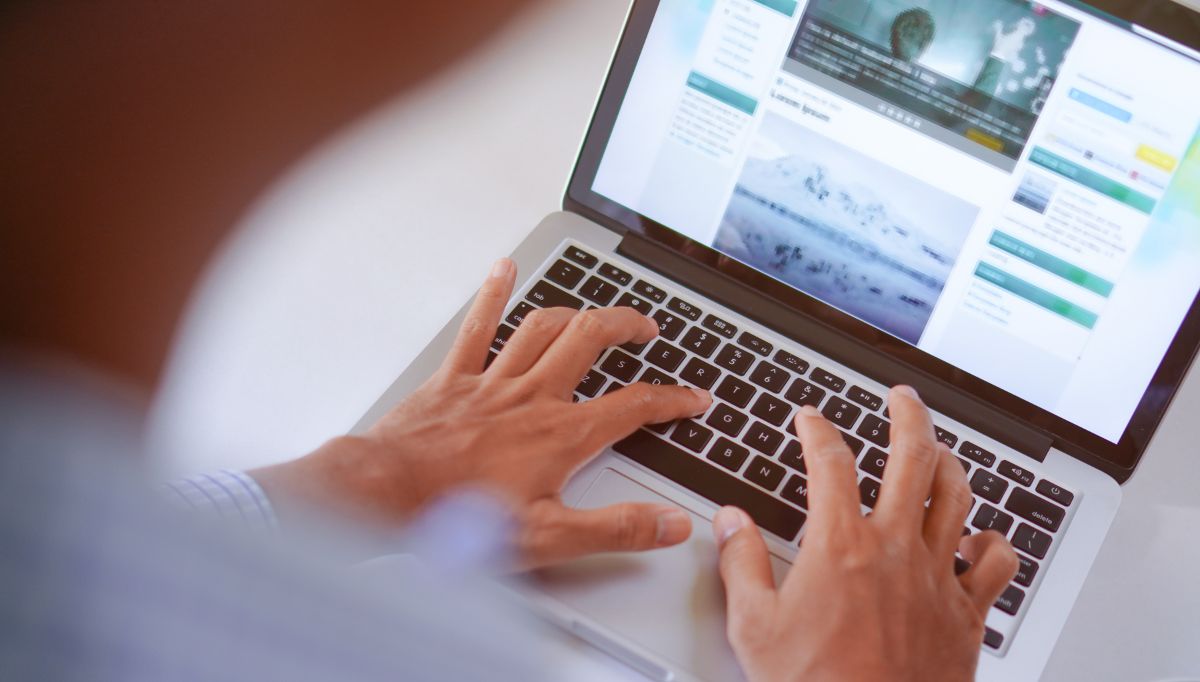 man typing on laptop keyboard