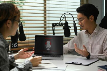 Male radio host using condenser microphone recording voiceover