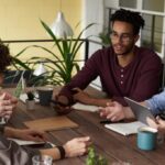 photo of people leaning on wooden table