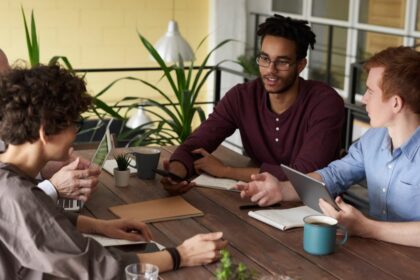 photo of people leaning on wooden table