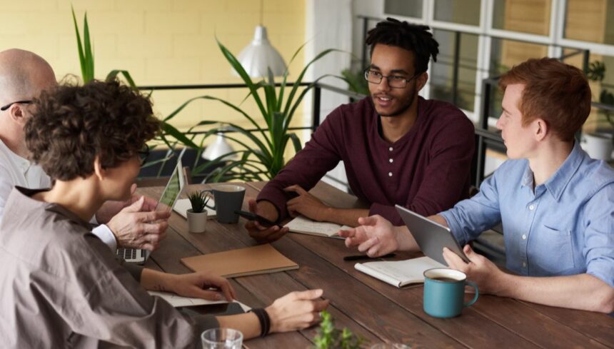 photo of people leaning on wooden table