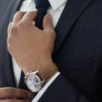 Man knotting his necktie while dressing