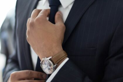 Man knotting his necktie while dressing