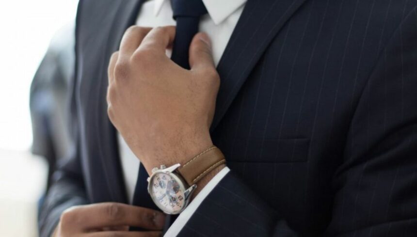 Man knotting his necktie while dressing