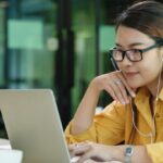 woman wearing headphones engage in online learning