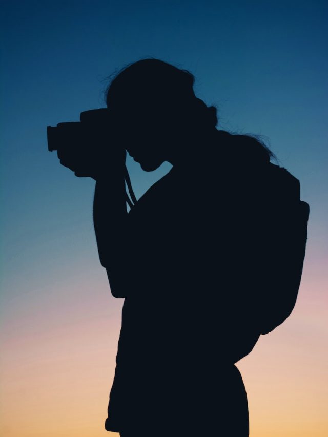 Silhouette of Person Taking Photo With Camera