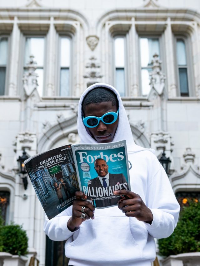 man in white thobe holding newspaper